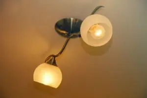 Wall with a light fixture attached to it, featuring two lights that are turned