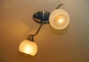 Wall with a light fixture attached to it, featuring two lights that are turned